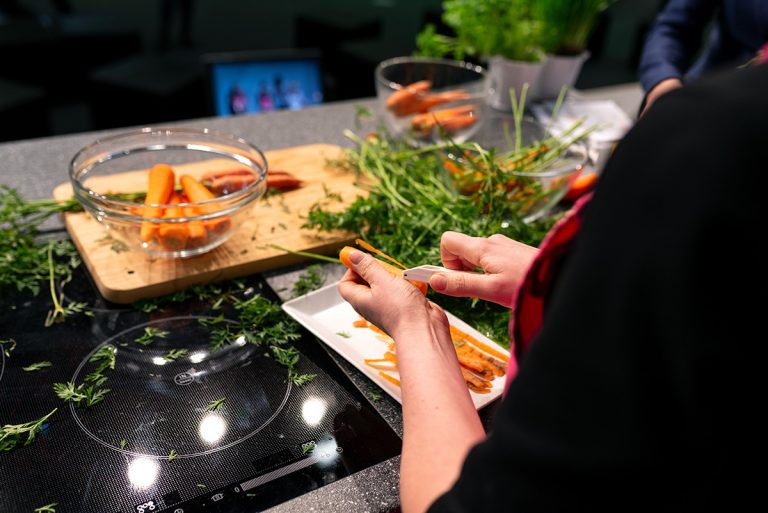 Mitarbeitende Person von RESTLOS GLÜCKLICH e. V. beim Schälen einer Karotte