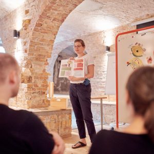 Edith Timm von RESTLOS GLÜCKLICH e. V. stellt ein Bildungsmaterial des Kitaprojekts „Bis auf den letzten Krümel" vor