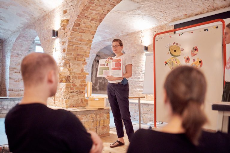 Edith Timm von RESTLOS GLÜCKLICH e. V. stellt ein Bildungsmaterial des Kitaprojekts „Bis auf den letzten Krümel" vor