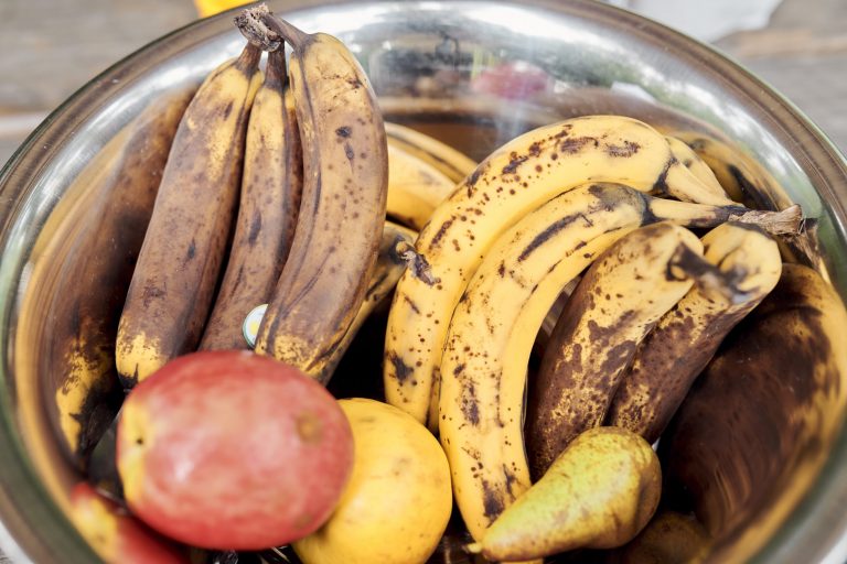 Eine Schüssel mit braunen Bananen, Äpfeln und einer Birne.