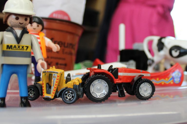 Ein Spielzeugtraktor und daneben zwei Lego-Figuren
