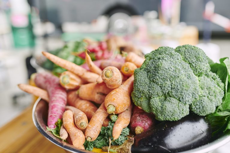 Eine Schüssel mit Karotten, Brokkoli, Aubergine und Salat