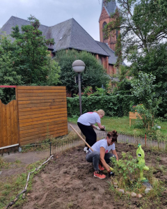 Zwei vom "Prima Klima"-Projektteam beim umackern einer Rasenfläche auf sich bald wilde Blumen, Gräser und Insekten wohlfühlen sollen.