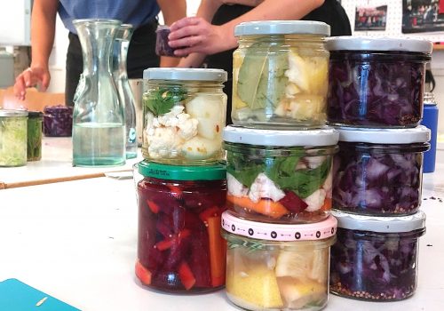 Gestapelte Einmachgläser mit fermentiertem Gemüse auf einem Tisch
